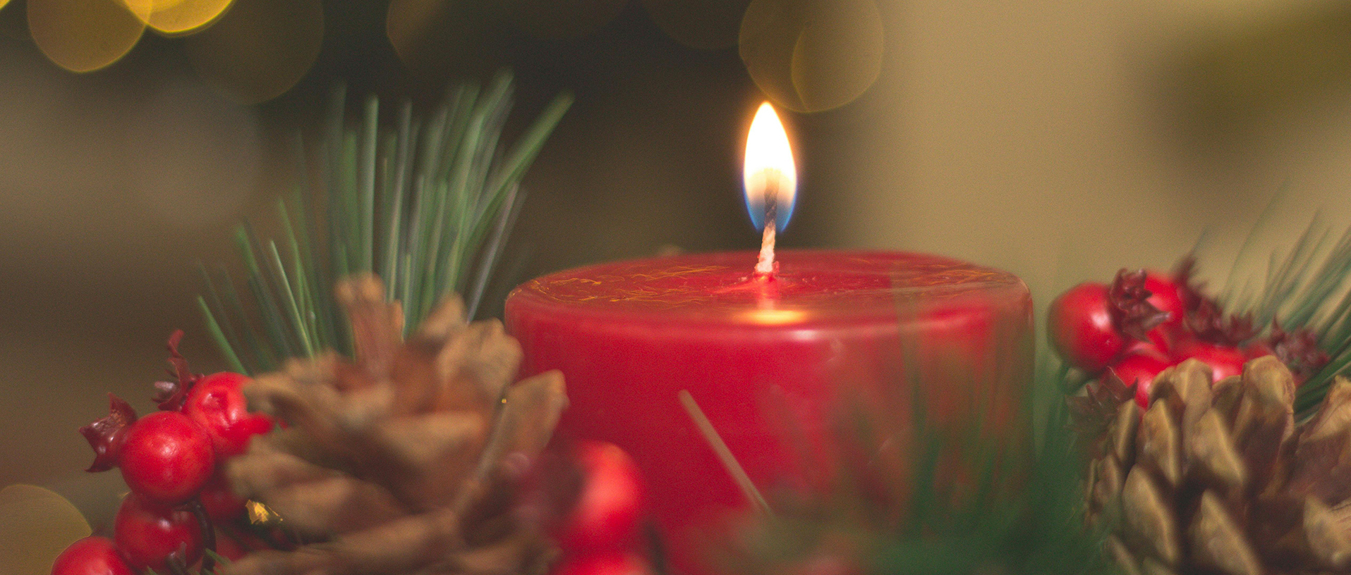 Brennende Adventskerze mit Dekoration