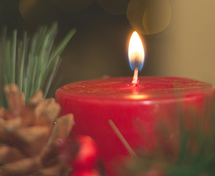 Brennende Adventskerze mit Dekoration