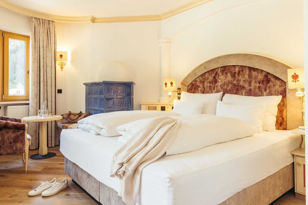 Doppelbett mit Sitzecke und Kachelofen im Romantik Appartement