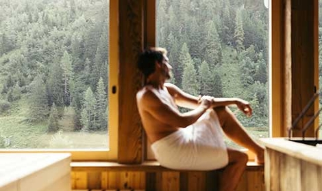 Mann sitzt auf Bank in der Panorama Sauna im Neuhintertux