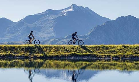 Zwei Mountainbiker beim Biken an einem Bergsee im Zillertal