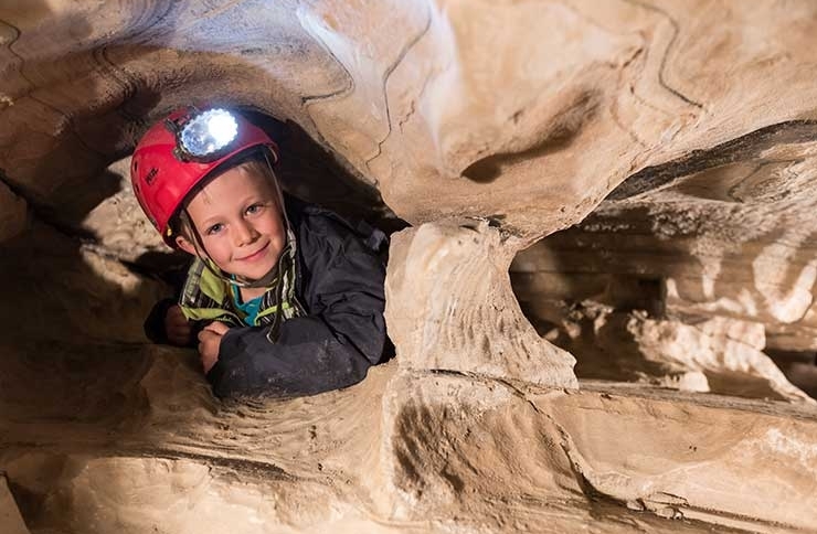 Kind mit Stirnlampe beim Erkunden der Spannaglhöhle am Hintertuxer Gletscher