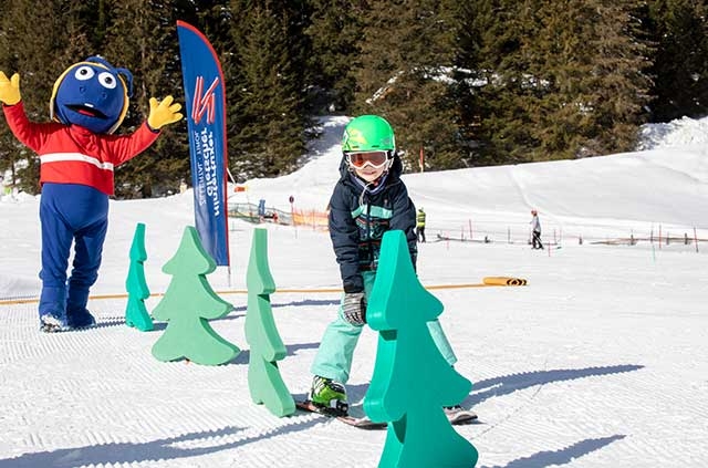 Kind beim Fahren durch Figuren im Familienurlaub in Hintertux