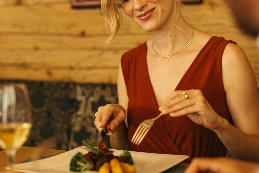 Frau genießt das Abendessen in der Jagdstube im Neuhintertux